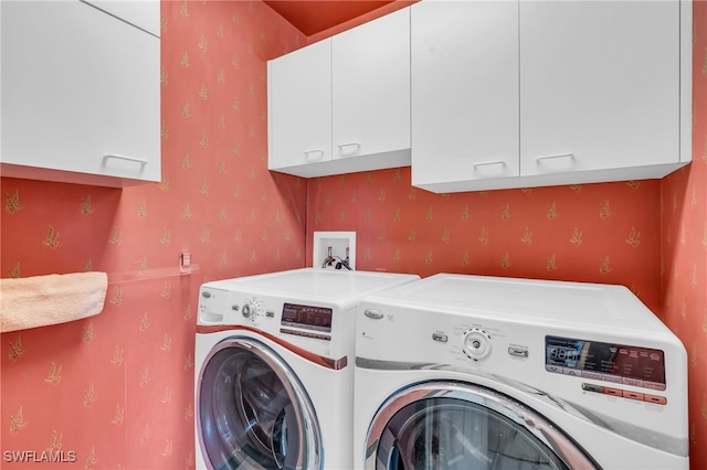 laundry room with washer and clothes dryer and cabinets