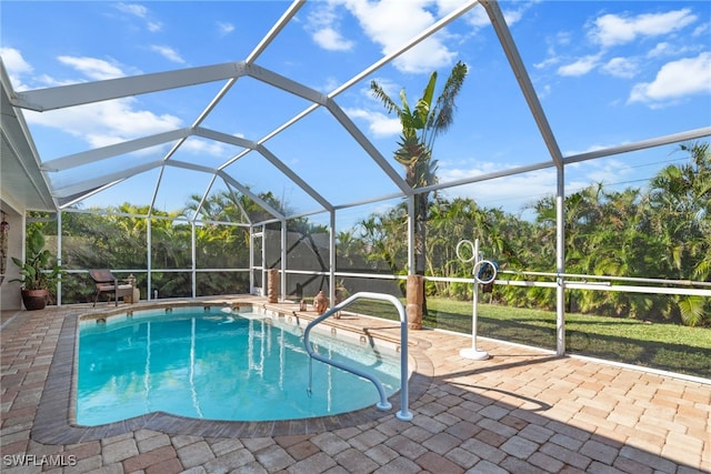 view of pool with glass enclosure and a patio