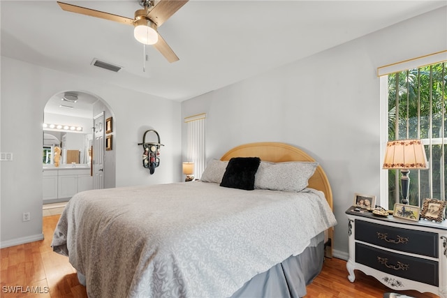 bedroom with ceiling fan, light wood-type flooring, and connected bathroom