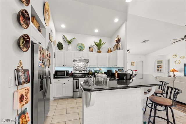 kitchen featuring a breakfast bar area, white cabinetry, and appliances with stainless steel finishes