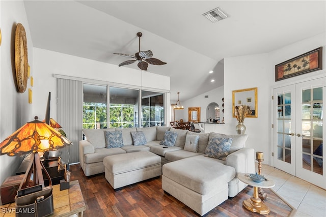 living room featuring hardwood / wood-style flooring, ceiling fan with notable chandelier, lofted ceiling, and french doors