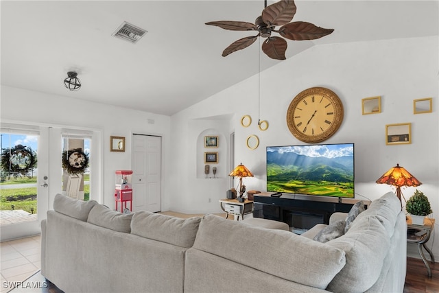 living room with ceiling fan, french doors, lofted ceiling, and light wood-type flooring