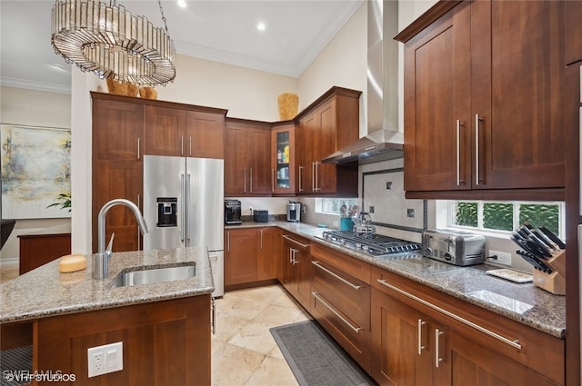 kitchen with a kitchen island with sink, wall chimney range hood, sink, light stone counters, and stainless steel appliances