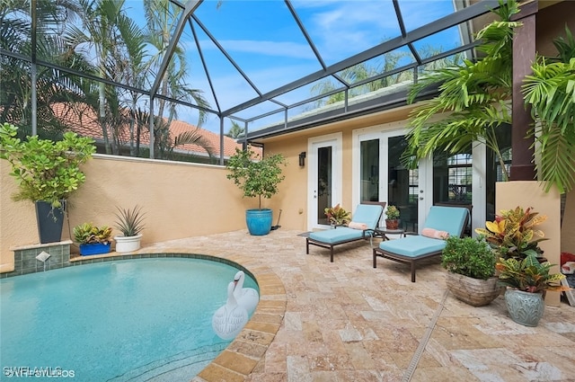 view of swimming pool featuring glass enclosure and a patio