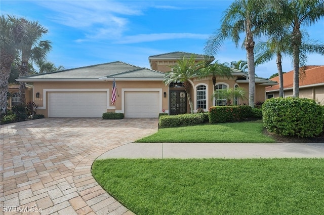 view of front of home with a front yard and a garage