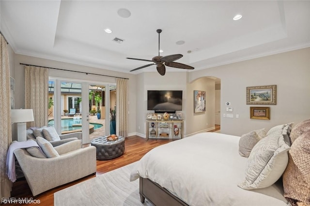 4908 Rustic Oaks Cir, Naples, FL 34105 - bedroom with a tray ceiling, access to outside, arched walkways, wood finished floors, and recessed lighting