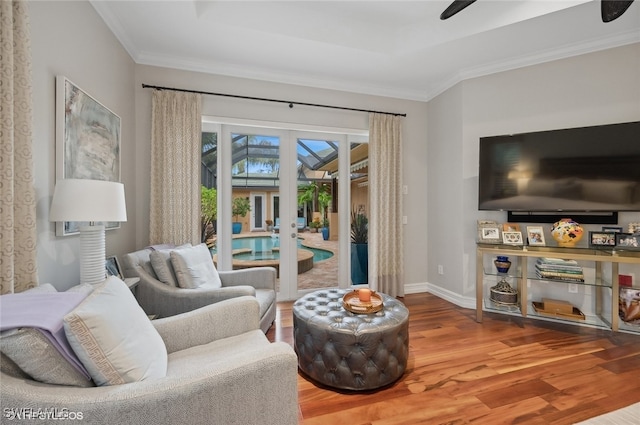 living room featuring wood-type flooring, french doors, and crown molding