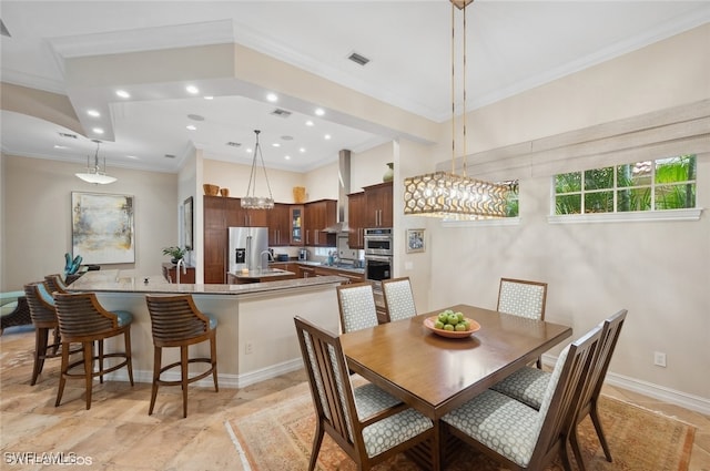 dining space featuring ornamental molding and sink