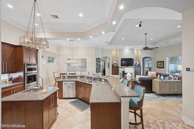 4908 Rustic Oaks Cir, Naples, FL 34105 - kitchen with stainless steel appliances, a sink, a spacious island, a tray ceiling, and recessed lighting