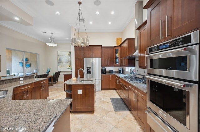 kitchen featuring light stone countertops, an inviting chandelier, pendant lighting, a center island with sink, and appliances with stainless steel finishes