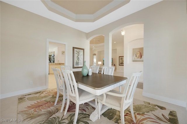 dining room with a tray ceiling and crown molding