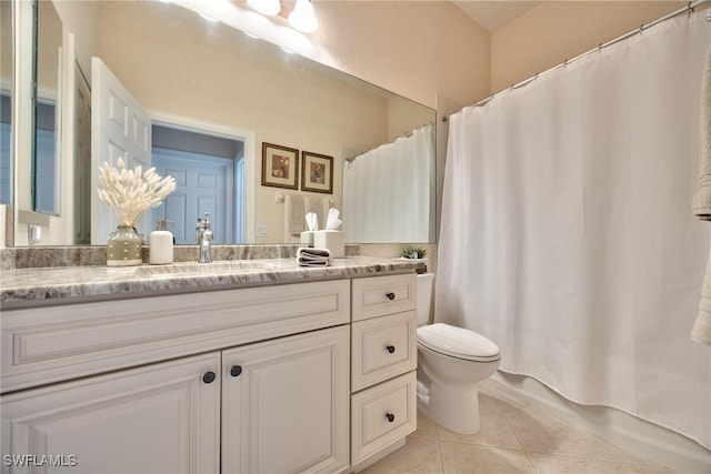 bathroom with toilet, vanity, and tile patterned floors