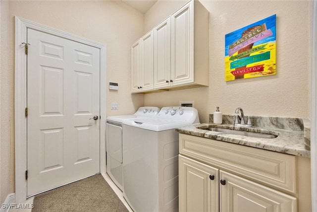 washroom featuring washer and dryer, cabinets, and sink