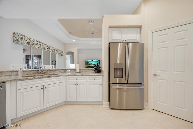 kitchen with white cabinets, appliances with stainless steel finishes, light stone counters, and sink