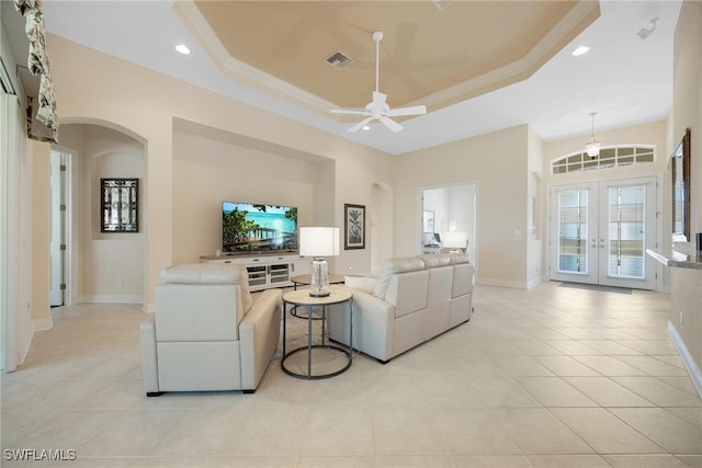 living room with ceiling fan, light tile patterned floors, ornamental molding, and french doors