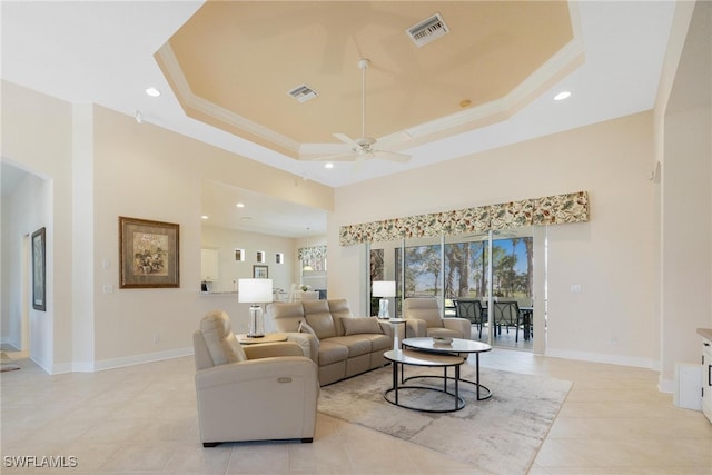 tiled living room featuring ceiling fan, a towering ceiling, crown molding, and a tray ceiling