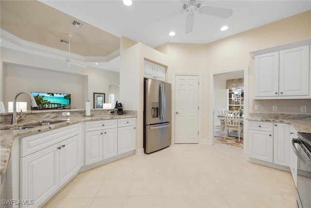 kitchen featuring white cabinets, appliances with stainless steel finishes, light stone countertops, and sink