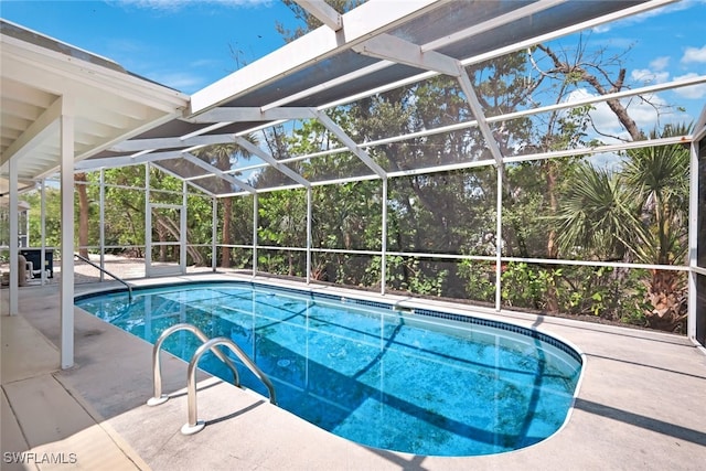 view of swimming pool with a patio area and a lanai