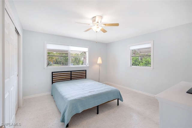 bedroom featuring a closet, ceiling fan, and multiple windows