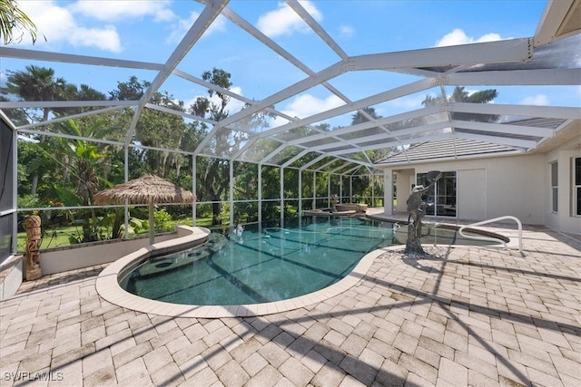 view of pool with an in ground hot tub, a patio area, and glass enclosure