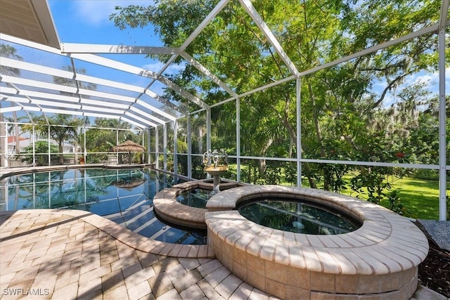 view of swimming pool featuring an in ground hot tub, a patio area, and a lanai