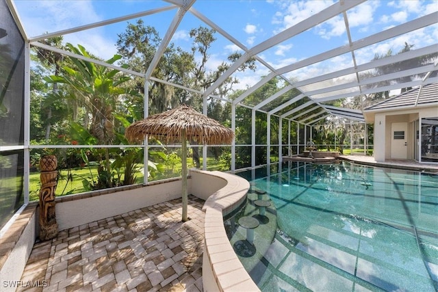 view of pool with a patio and glass enclosure