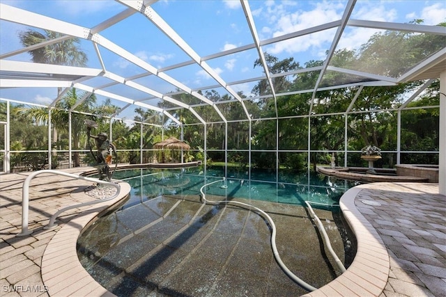 view of pool with a patio area and glass enclosure