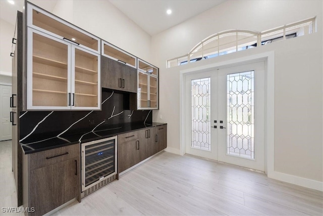 kitchen with french doors, dark brown cabinets, light wood-type flooring, and beverage cooler