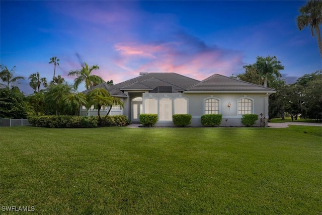 12800 Treeline Ct, North Fort Myers, FL 33903 - view of front of house with a yard, stucco siding, and a tile roof