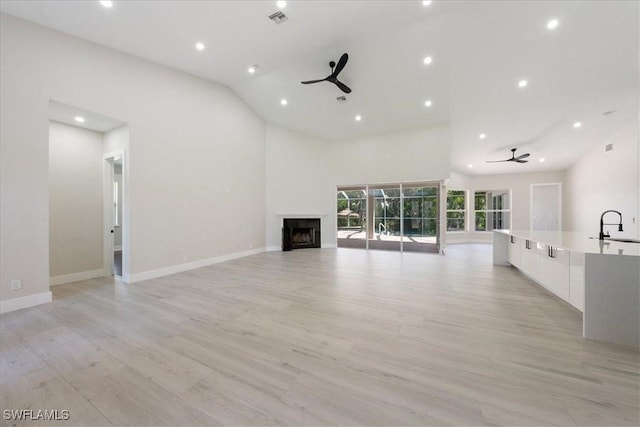 12800 Treeline Ct, North Fort Myers, FL 33903 - unfurnished living room with a ceiling fan, a fireplace, light wood finished floors, recessed lighting, and high vaulted ceiling