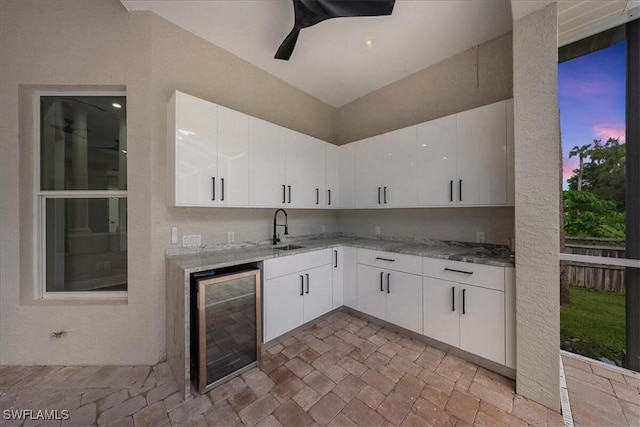 12800 Treeline Ct, North Fort Myers, FL 33903 - kitchen featuring beverage cooler, light stone counters, white cabinets, a ceiling fan, and lofted ceiling