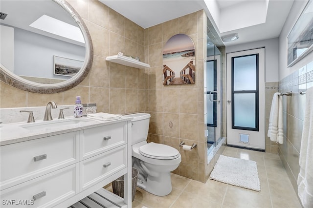 bathroom featuring tile patterned flooring, vanity, tile walls, and walk in shower