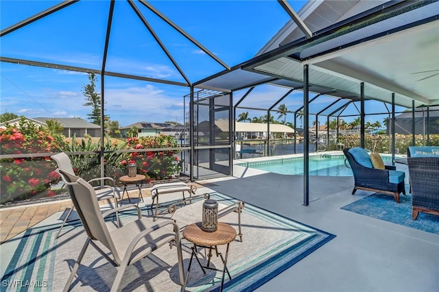 view of patio featuring ceiling fan and glass enclosure