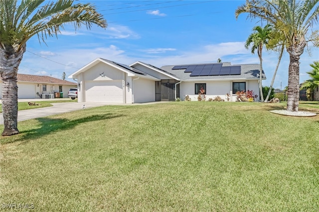 ranch-style house featuring a garage, a front yard, and solar panels