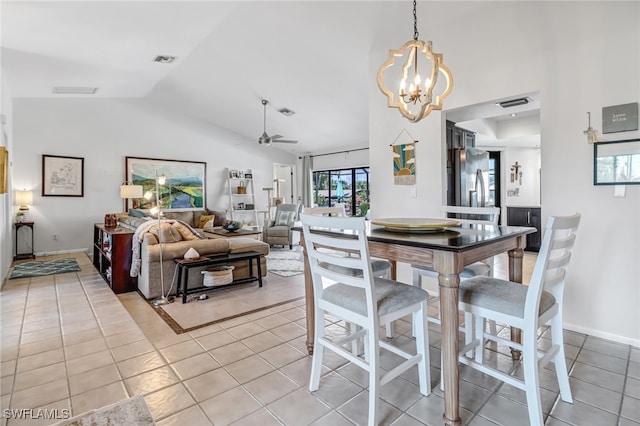 dining area with light tile patterned flooring, ceiling fan with notable chandelier, and vaulted ceiling