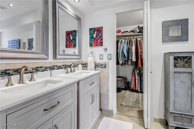 bathroom with tile patterned flooring, vanity, and tile walls