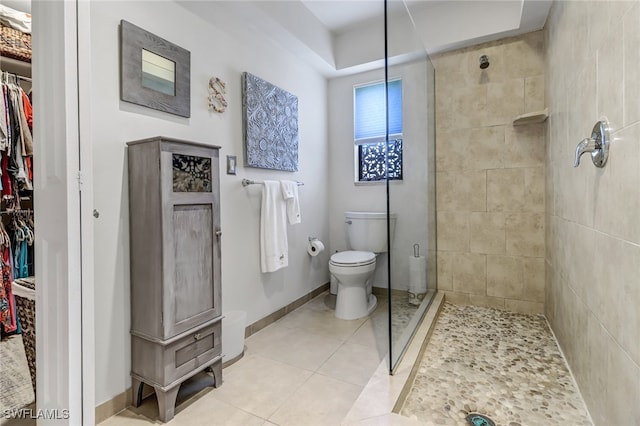 bathroom with tile patterned flooring, toilet, and walk in shower