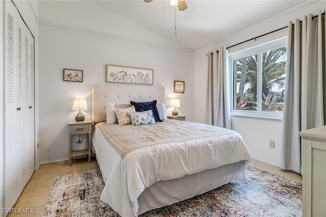 tiled bedroom featuring vaulted ceiling, a closet, and ceiling fan