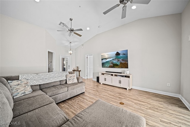 living room featuring ceiling fan with notable chandelier, vaulted ceiling, and light hardwood / wood-style flooring