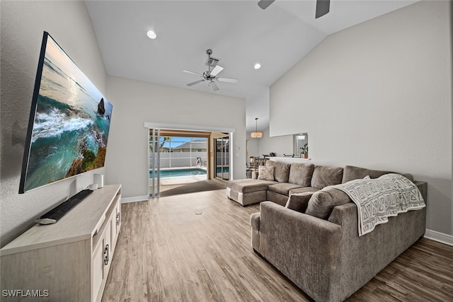 living room featuring hardwood / wood-style flooring, ceiling fan, and vaulted ceiling