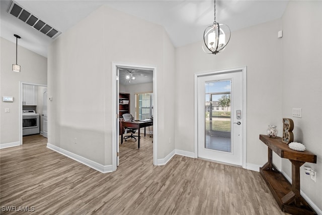 entryway featuring an inviting chandelier, high vaulted ceiling, and hardwood / wood-style flooring