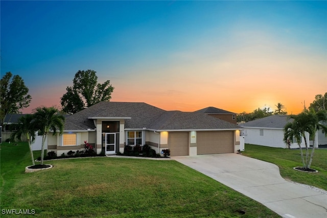 view of front of home with a garage and a lawn