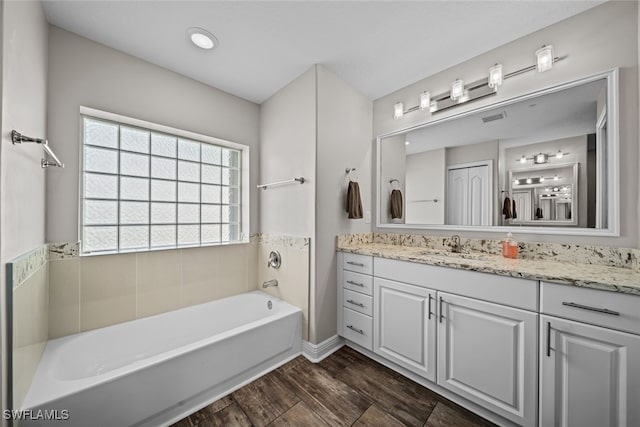 bathroom featuring hardwood / wood-style floors, vanity, and a tub