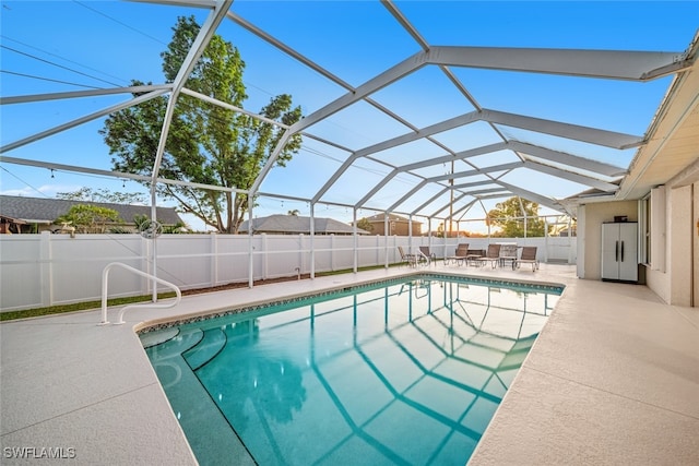 view of pool with glass enclosure and a patio