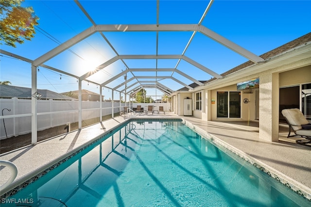 view of pool with glass enclosure and a patio area