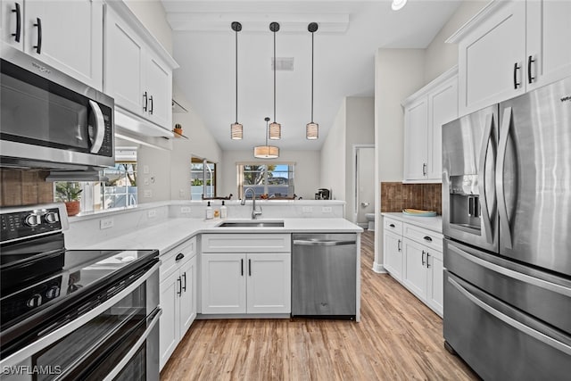 kitchen with a wealth of natural light, white cabinetry, sink, and appliances with stainless steel finishes