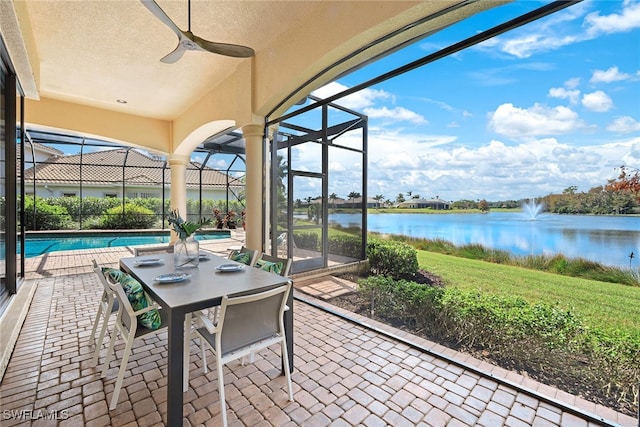 sunroom featuring a water view and ceiling fan