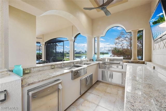 view of patio featuring sink, a water view, ceiling fan, exterior kitchen, and area for grilling