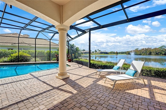 view of pool featuring a patio, a water view, and a lanai