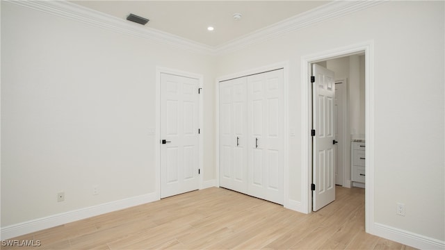 unfurnished bedroom with light hardwood / wood-style floors, a closet, and ornamental molding